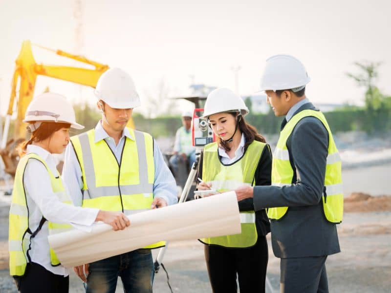 Land surveyors reviewing an ALTA survey plan at a commercial property site